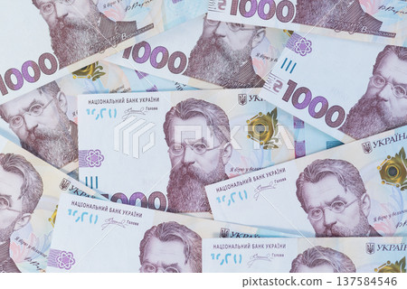 Top view of scattered 1000 Ukrainian hryvnia banknotes featuring Volodymyr Vernadsky. 137584546