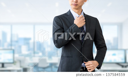 A male businessman standing with a stern expression A male businessman standing with a stern expression 137584559