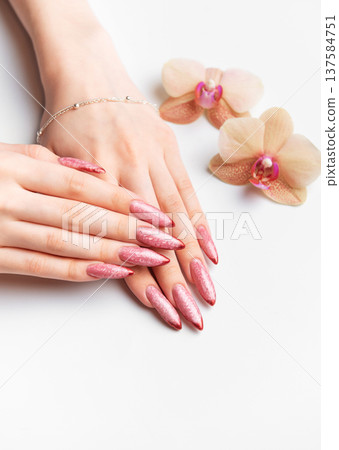 Woman showing elegant pink sparkling pointed nails 137584751