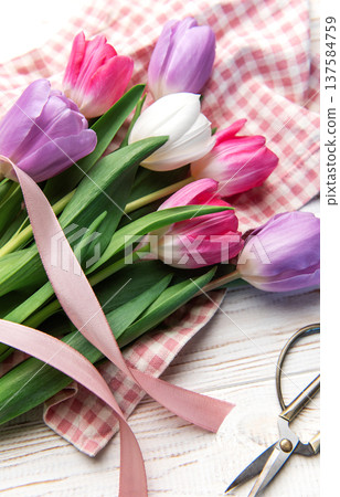 Colorful tulip bouquet with ribbon on white wooden background 137584759