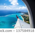 A stunning aerial view of a beautiful turquoise beach and pristine coastline seen from an airplane porthole 137584918