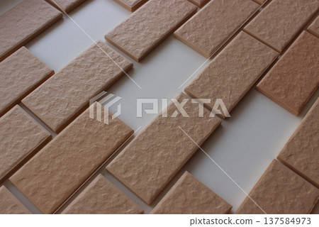 Missing areas on surface covered in even rows of wall tiles with brickwork  imitation 137584973