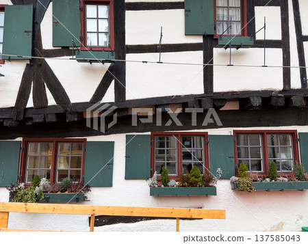 Hotel Schiefes Haus in Ulm, Germany, known for its unique crooked structure. The building features traditional timber framing and green shutters. Hotel Schiefes Haus in Ulm, Germany, known for its unique crooked structure. The building features traditional timber framing and green shutters. 137585043