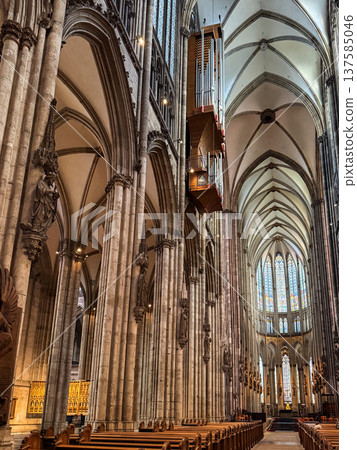 Interior view of Cologne Cathedral in Germany. Tall stone columns, intricate arches, and colorful stained glass windows create a majestic atmosphere. Interior view of Cologne Cathedral in Germany. Tall stone columns, intricate arches, and colorful stained glass windows create a majestic atmosphere. 137585046