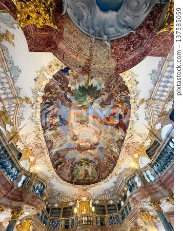 Grand library in Wiblingen Abbey, Ulm, Germany. Baroque interior with ornate columns, frescoed ceilings, and shelves filled with books. Grand library in Wiblingen Abbey, Ulm, Germany. Baroque interior with ornate columns, frescoed ceilings, and shelves filled with books. 137585059