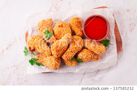 fried chicken legs in breadcrumbs, on a wooden chopping board, with red sauce, no people, 137585232
