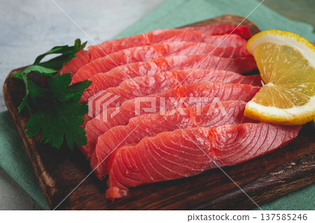 chum salmon, cold smoked, sliced, on a cutting board, with lemon and parsley, top view, close-up, no people, 137585246