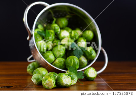 fresh brussels sprouts in metal colander on wooden table fresh brussels sprouts in metal colander on wooden table 137585878