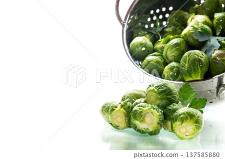 fresh brussels sprouts in metal colander on white background fresh brussels sprouts in metal colander on white background 137585880