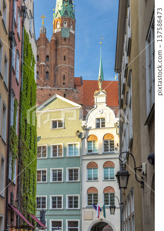 Gdansk, a city on the Baltic coast of northern Poland, Europe. European architecture presents a vintage charm with ivy-covered facades and a prominent church steeple reaching into the bright blue sky. Gdansk, a city on the Baltic coast of northern Poland, Europe. European architecture presents a vintage charm with ivy-covered facades and a prominent church steeple reaching into the bright blue sky. 137586473