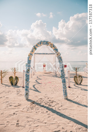 Romantic sunset beach wedding arch decorated flowers sandy shore radiant ocean horizon love couple tropical destination ceremony 137587318