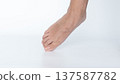 Close-up of a bare foot with well-groomed toes, showcasing skin texture and natural beauty against a clean white background with copy space 137587782