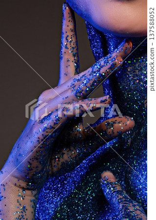 Glitter covers hands and neck during a creative art event in the evening hours Glitter covers hands and neck during a creative art event in the evening hours 137588052