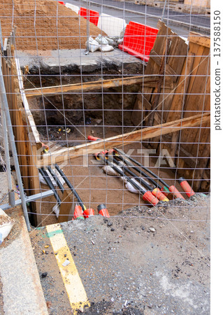 black plastic pipes in ground for drainage of sewage rainwater, lying in trench of sand. black plastic pipes in ground for drainage of sewage rainwater, lying in trench of sand. 137588150
