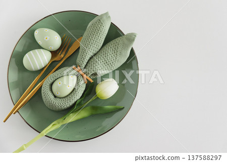 Easter Table Setting with Bunny Napkin, Decorated Eggs and Tulips. Festive Spring Arrangement 137588297