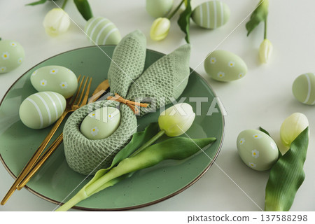 Easter Table Setting with Bunny Napkin, Decorated Eggs and Tulips. Festive Spring Flat Lay 137588298