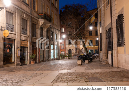 Lyon, france. December 28, 2023. Vieux lyon, france, a charming cobblestone street illuminated at night, featuring historic buildings and a dormant tree 137588338