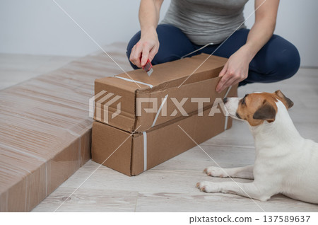 A Caucasian woman unpacks a box of furniture. 137589637