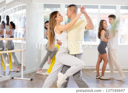 Happy young caucasian man and woman dancing paired latin dance in ballroom Happy young caucasian man and woman dancing paired latin dance in ballroom 137589847
