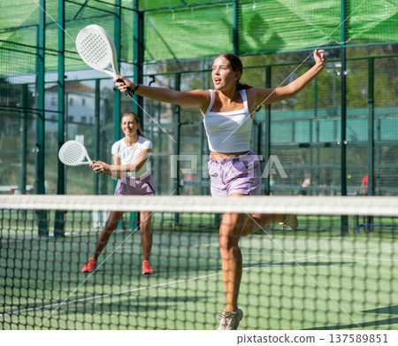 Padel game - woman with partners plays on tennis court Padel game - woman with partners plays on tennis court 137589851