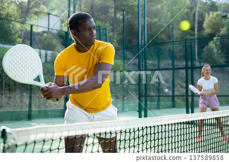 Man playing padel tennis on court 137589858