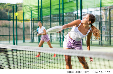 Padel game - woman with partners plays on tennis court Padel game - woman with partners plays on tennis court 137589866