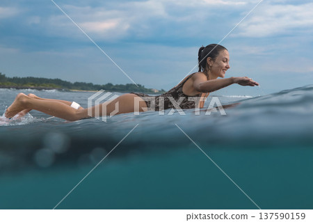 Eager Young Lady Balancing On Surfboard During Sunrise Peaceful Ocean 137590159