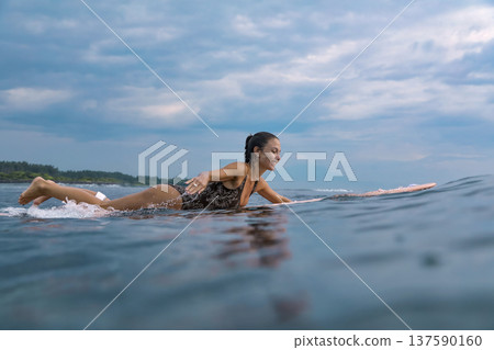 Energetic Young Woman Refining Her Surfing Abilities Confidently 137590160