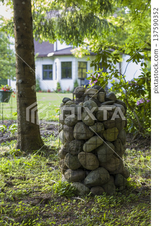 Stone structure in a lush garden surrounded by trees and flowers during daylight 137590352