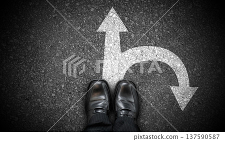 Black business shoes and two forward and backward arrows on asphalt Black business shoes and two forward and backward arrows on asphalt 137590587