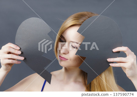 Young sad woman covered by broken heart. Young sad woman covered by broken heart. 137590774