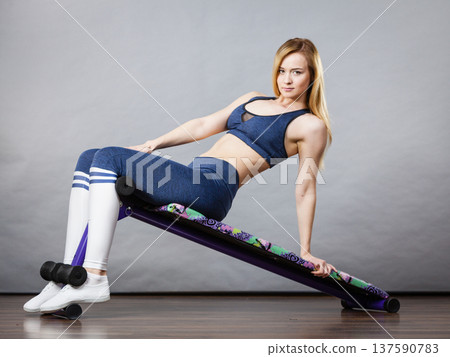 Woman training on bench for sit ups 137590783
