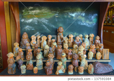 Sakata, Yamagata, japan - Oct 5 2024, Klous ap ivd on a stand with small terracotta figurines in the form of people, each with a coin on their forehead, in the temple, Sakata, Japan Sakata, Yamagata, japan - Oct 5 2024, Klous ap ivd on a stand with small terracotta figurines in the form of people, each with a coin on their forehead, in the temple, Sakata, Japan 137591084
