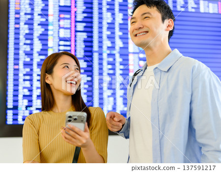 Two people looking at an airport sign ■Photography cooperation: Kansai International Airport (KIX) Two people looking at an airport sign ■Photography cooperation: Kansai International Airport (KIX) 137591217