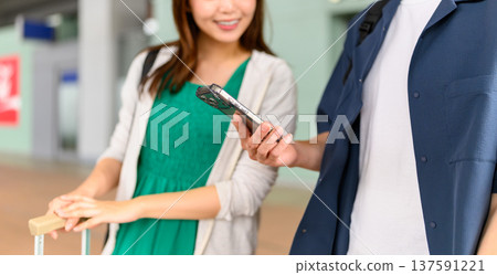 A couple checking their smartphones at the airport. Photo courtesy of Kansai International Airport (KIX) A couple checking their smartphones at the airport. Photo courtesy of Kansai International Airport (KIX) 137591221