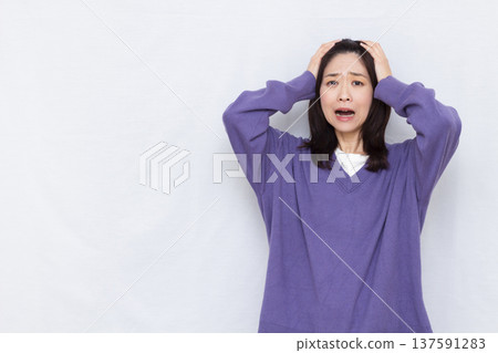 Surprised woman holding her head 137591283
