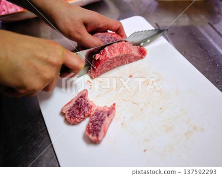 A female chef cutting domestically produced Japanese Black beef thigh meat 137592293