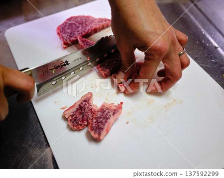 A female chef cutting domestically produced Japanese Black beef thigh meat 137592299