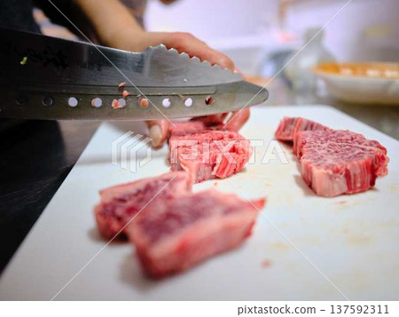 A female chef cutting domestically produced Japanese Black beef thigh meat A female chef cutting domestically produced Japanese Black beef thigh meat 137592311