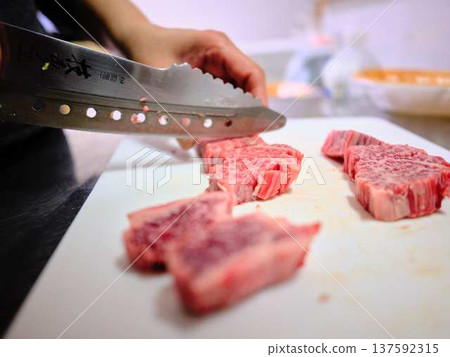 A female chef cutting domestically produced Japanese Black beef thigh meat 137592315