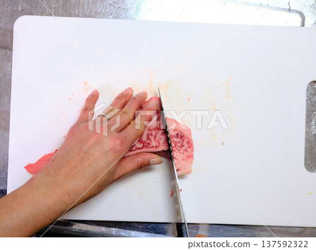 A female chef cutting domestically produced Japanese Black beef thigh meat 137592322