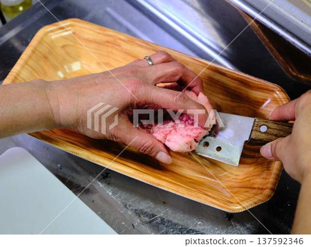 A female chef cutting domestically produced Japanese Black beef thigh meat 137592346