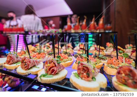 Assorted gourmet canapes with salami salmon and vegetables served on a glass buffet table Assorted gourmet canapes with salami salmon and vegetables served on a glass buffet table 137592559