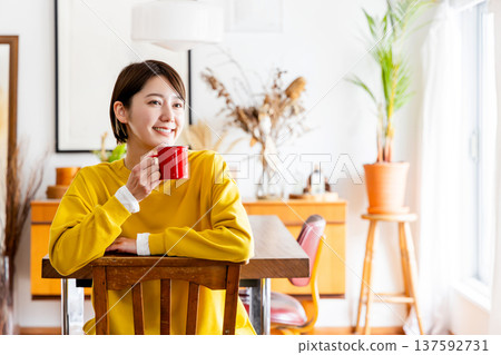 一位女士背對著坐在椅子上喝咖啡 137592731