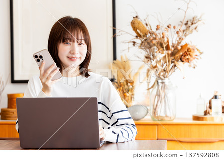 一位年輕女子在客廳在家工作 一位年輕女子在客廳在家工作 137592808