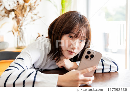 A woman looking at her smartphone in the living room 137592886