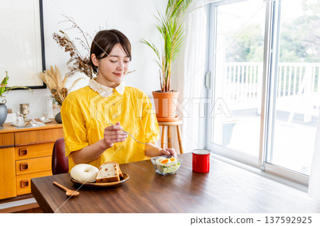 女性在房間裡吃早餐 女性在房間裡吃早餐 137592925