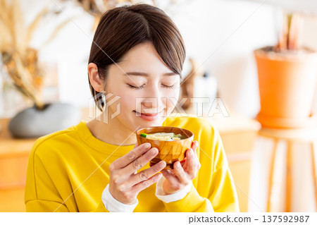 一個女人手裡拿著溫暖的味噌湯 一個女人手裡拿著溫暖的味噌湯 137592987