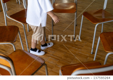 孩子們在教室裡圍成一個圓圈站在椅子上。 137593264