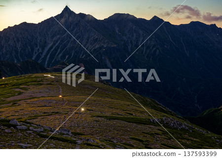 從雙六山眺望北阿爾卑斯山脈、槍岳以及黎明時分登山者的燈光。 從雙六山眺望北阿爾卑斯山脈、槍岳以及黎明時分登山者的燈光。 137593399